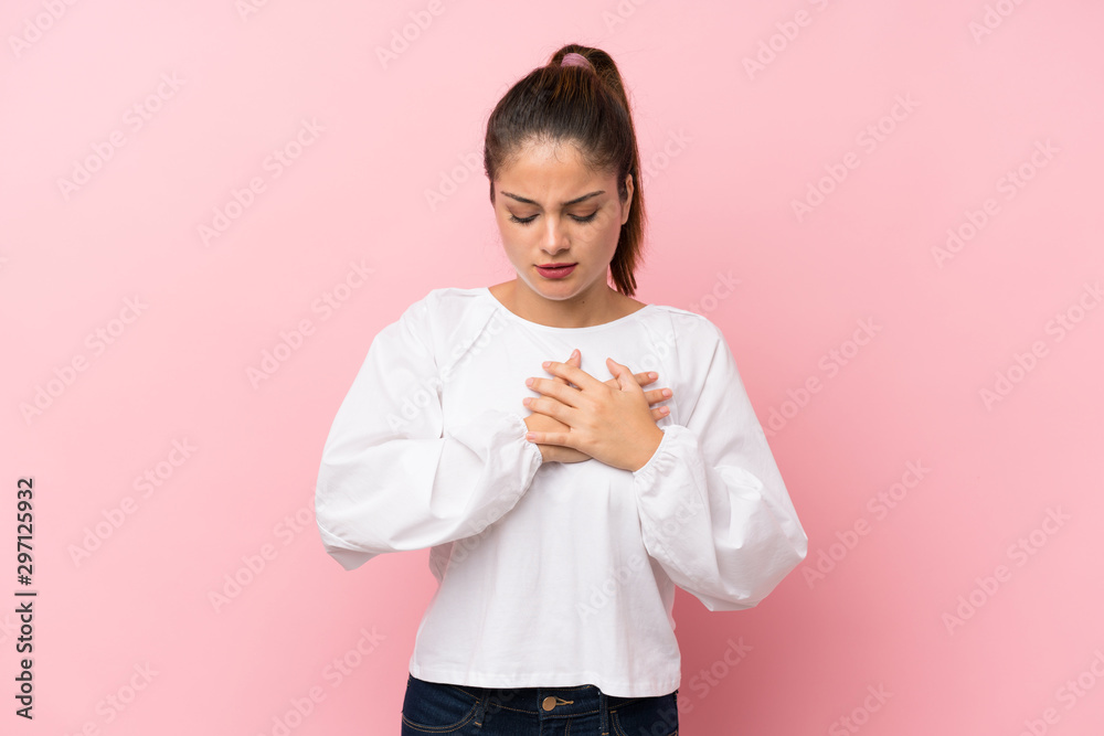 Young brunette girl over isolated pink background having a pain in the heart Young brunette girl over isolated pink background having a pain in the heart