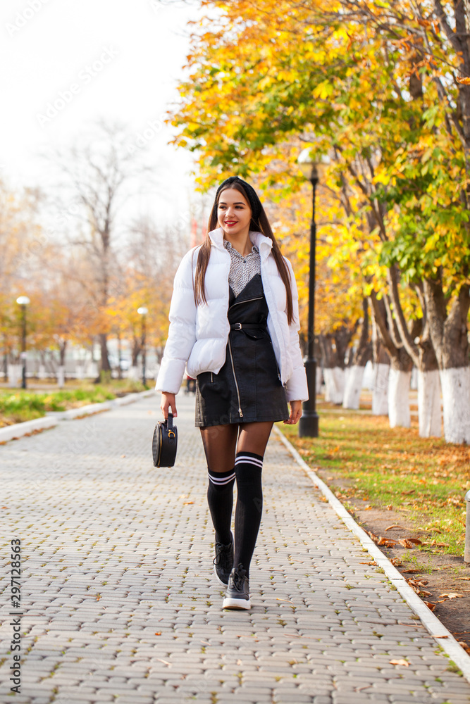 Portrait of a young beautiful woman in a white down jacket