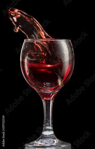 a splash of red wine in a glass on a black background