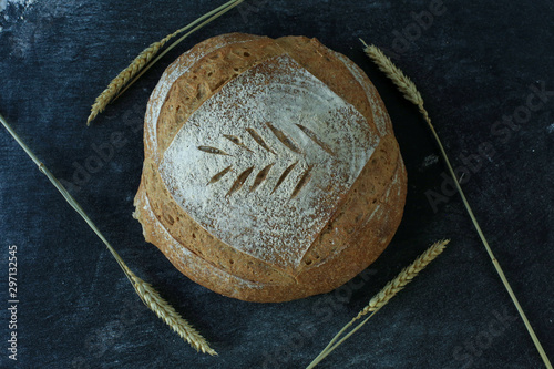 Fresh homemade bread. round bread on a dark background. Mother dough bread. Homemade bread sourdough, rustic baked bread photo