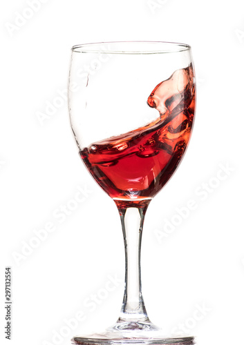 a splash of red wine in a glass on a white background