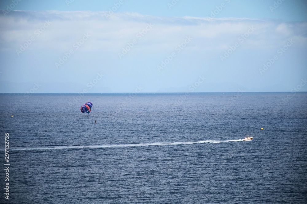 Parasailing, parachute pulled by a motorboat in the ocean, island of Madeira