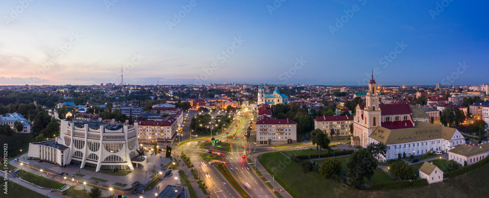 Grodno Regional Drama Theater and Holy Cross Church And Traffic In Mostowaja And Kirova Streets in the morning light. Grodno city in Belarus. Aerial view from a drone