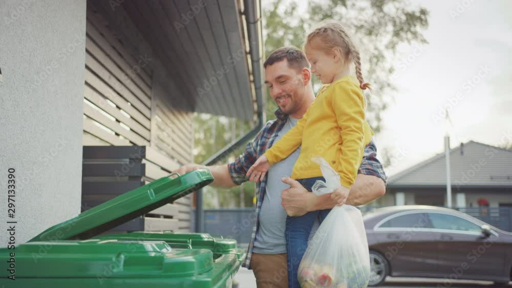 Happy Father Holding a Young Girl and Going to Throw Away an Empty Bottle and Food Waste into the Trash. They Use Correct Garbage Bins Because This Family is Sorting Waste and Helping the Environment.