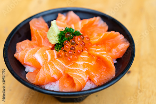 Close up of salmon don, fresh sashimi, raw salmon, salmon roe , wasabi on wooden table. Copy space.