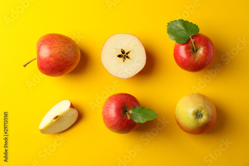 Flat lay with red apples on yellow background, space for text