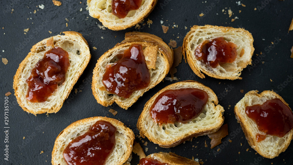 Croissant z dżemem leżący na ciemnym tle. Widok z góry, zbliżenie.