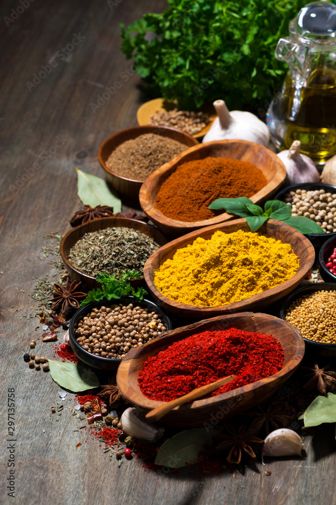 assortment of oriental spices on a wooden background, vertical