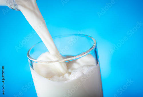 Fotografia milk pouring from bottle into glass