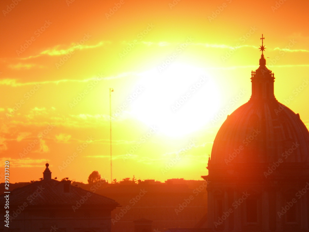 Skyline with the setting sun over Rome's rooftops seen from the Caffarelli terrace. Church domes and city profile.