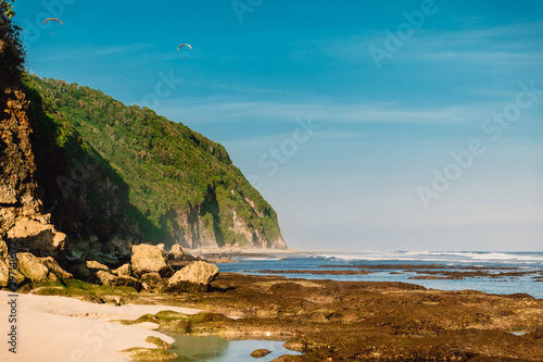 Tropical sandy beach with rocks and ocean