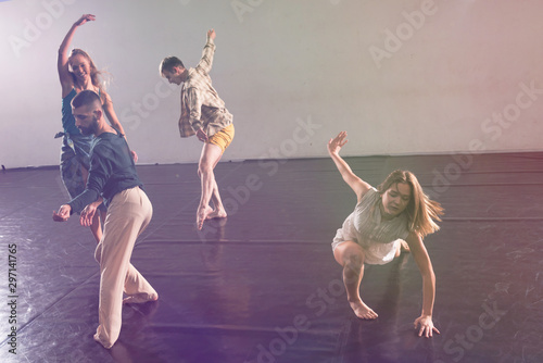 Young modern dancers dancing in the studio. Sport, dancing and urban culture concept. Group of young dancers performing on the stage. Effective performance. beautiful dance. full of energe dancers.