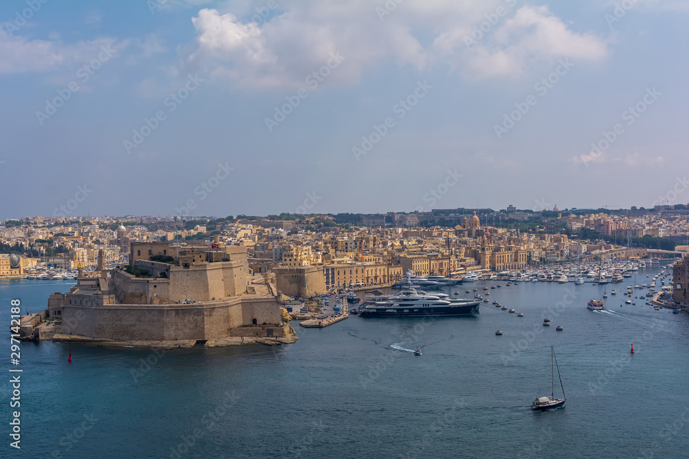 View to the Fort St. Angelo, with part of the city Birgu (Vittoriosa), and to the Grand Harbour Marina full with luxury yachts and ships. View to the Fort St. Angelo from Valletta, Malta.