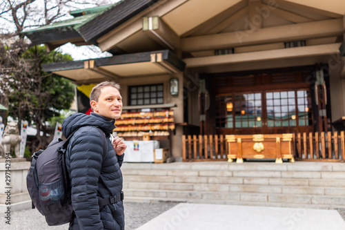 Tokyo, Japan Togo shrine temple exterior building entrance with happy tourist man standing on street in Shibuya Harajuku