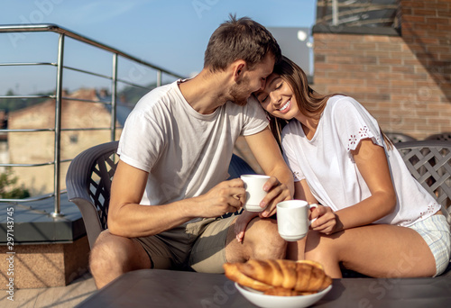 Young spouses revelling in their unhurried morning outdoor breakfast