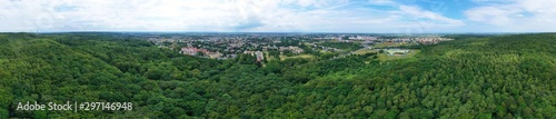Aerial drone wide panoramic view on green lungs forest surrounding european city during summer, aquapark complex