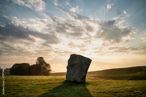 Stunning Summer sunrise landscape of Neolithic standing stones in English cluntryside with gorgeous light with slight background mist photo