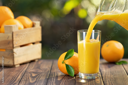 Fotografiet orange juice pouring in glass