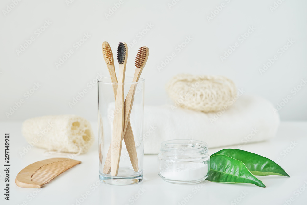 No plastic zero waste concept. Eco friendly wooden bamboo toothbrushes in a glass, towel, tooth powder and washcloth on white background No plastic zero waste concept. Eco friendly wooden bamboo toothbrushes in a glass, towel, tooth powder and washcloth on white background