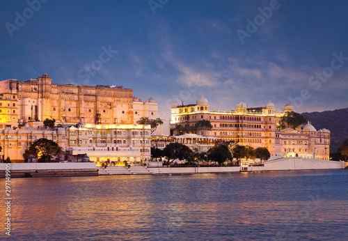 Panoramic view of the Udaipur City Palace at sunset from lake Pichola in Rajasthan, India