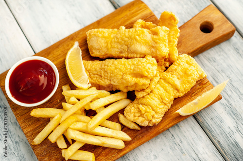 fish and chips with french fries, on wooden background 