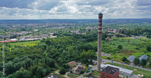 Aerial drone perspective view on high concrete chimney in heating plant close to the city photo