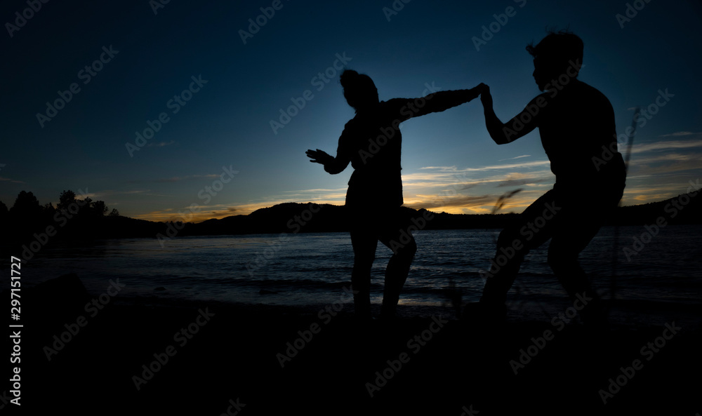 silhouette of couple dancing during sunset next to lake DIGITAL CAMERA