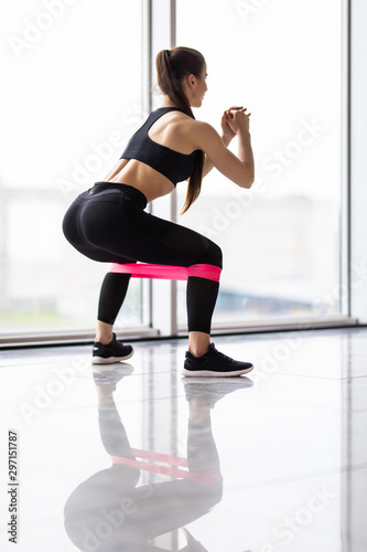 Young Woman exercising fitness resistance bands at gym