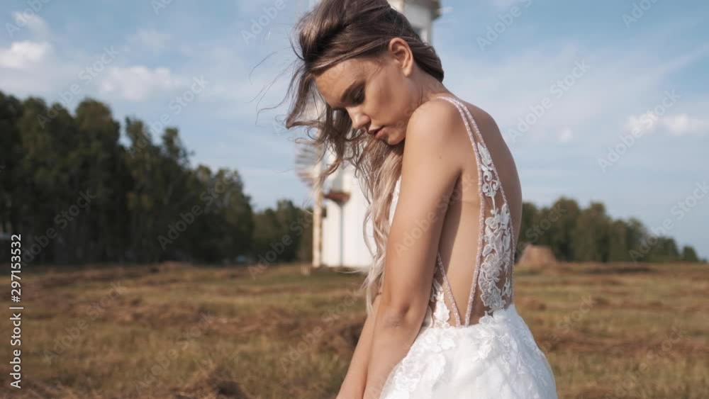 Attractive girl in a beautiful white dress in nature, the wind develops hair Attractive girl in a beautiful white dress in nature, the wind develops hair