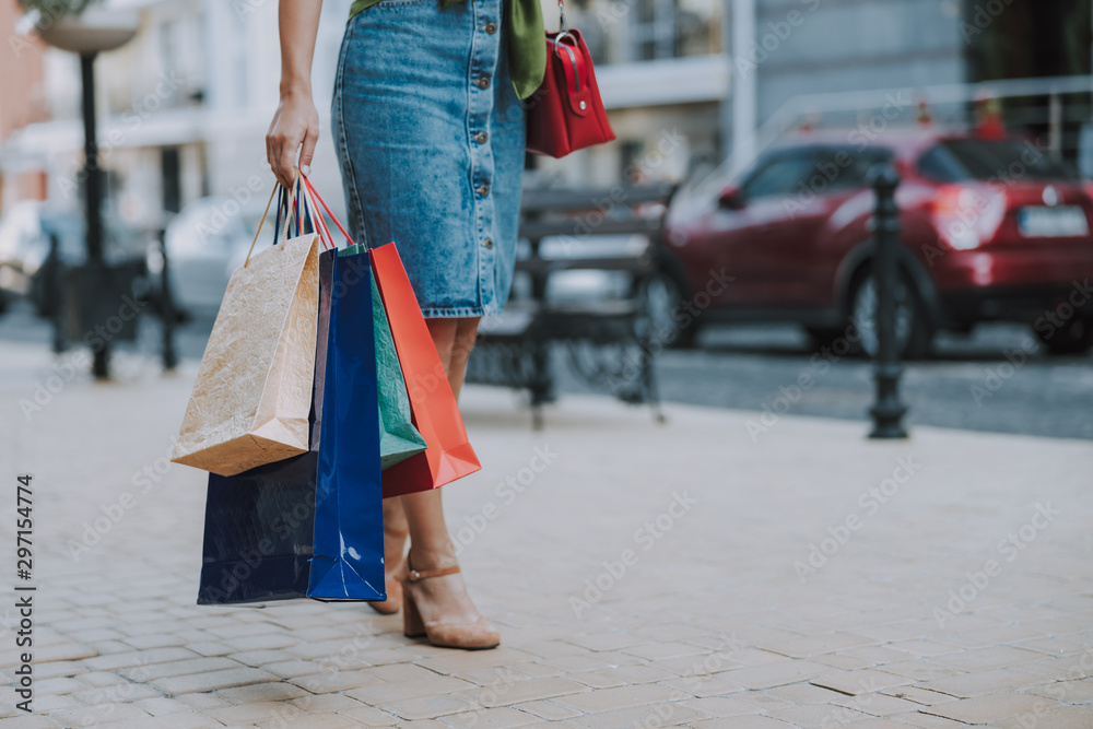 Young woman is standing with bags outdoors Young woman is standing with bags outdoors