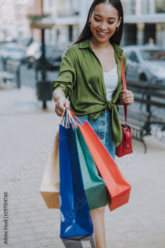 Happy young lady is holding shopping bags