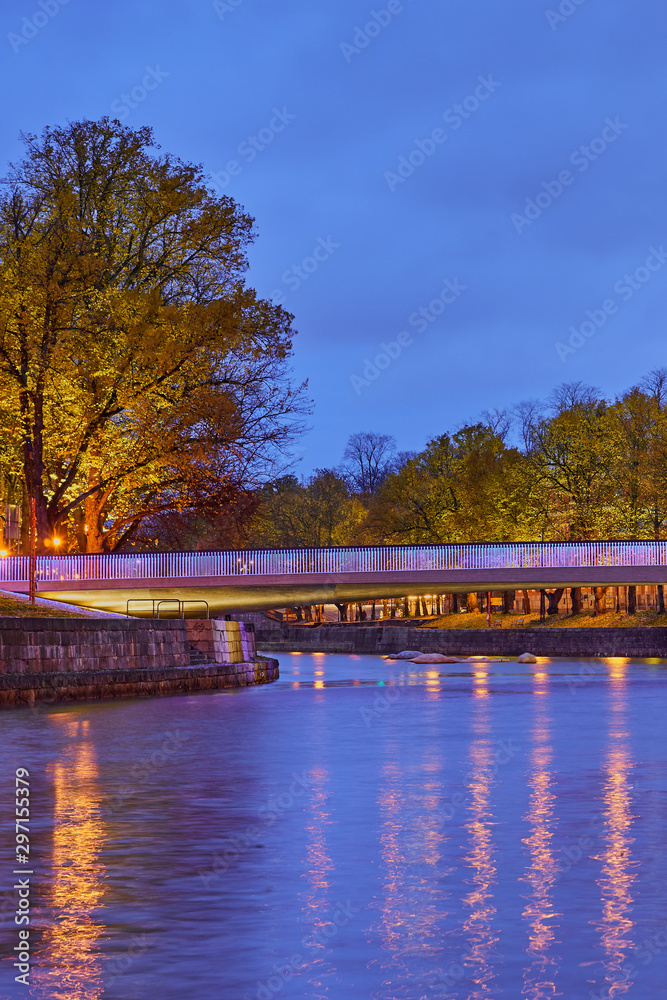                     The evening view of Aura river in Turku, Finland with a bridge on a background.           