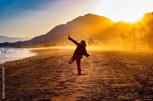 Silhouette of a girl on the beach at sunset photo