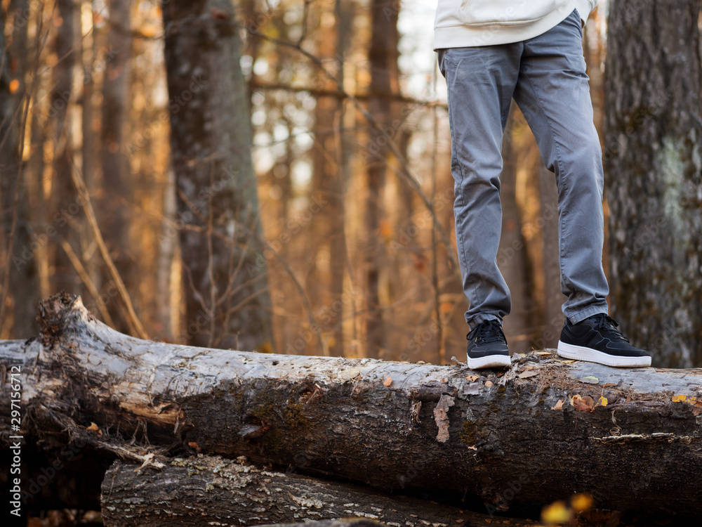Men's feet in stylish black sneakers in autumn Park or forest. Seasonal shoes. Copy space Men's feet in stylish black sneakers in autumn Park or forest. Seasonal shoes. Copy space