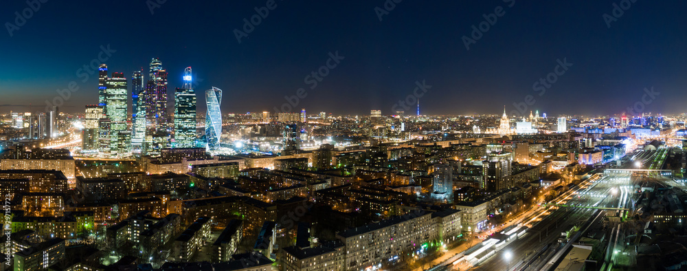 high-rise buildings and transport metropolis, traffic and blurry lights of cars on multi-lane highways and road junction at night in Moscow
