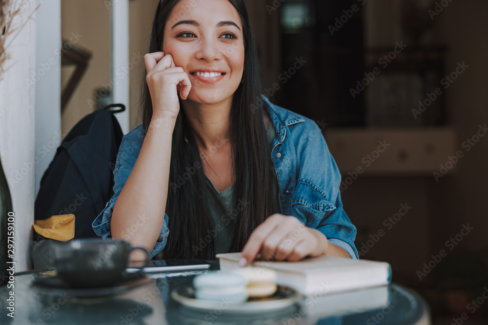 Pretty young woman with book in cafe