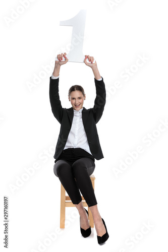 businesswoman holding number one overhead excited