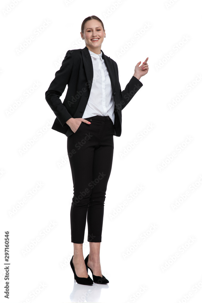 businesswoman standing with hand in pocket and pointing up