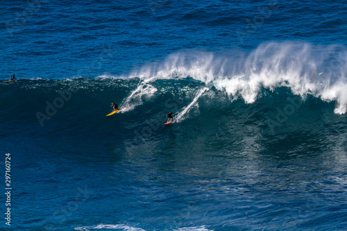 Surfers riding a big wave