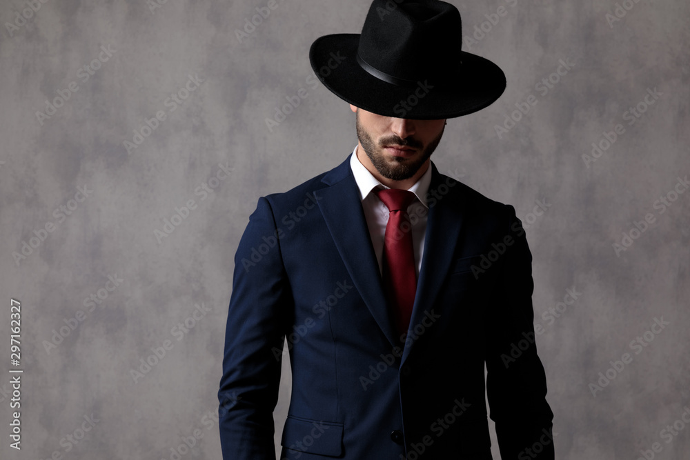 Mysterious businessman wearing a hat over his eyes Mysterious businessman wearing a hat over his eyes