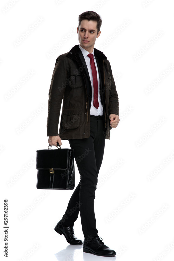 Serious looking businessman holding his briefcase Serious looking businessman holding his briefcase
