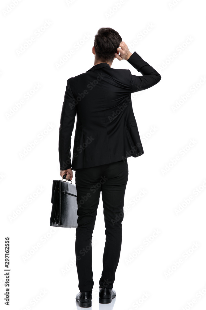 Rear view of an unsure businessman holding a briefcase Rear view of an unsure businessman holding a briefcase