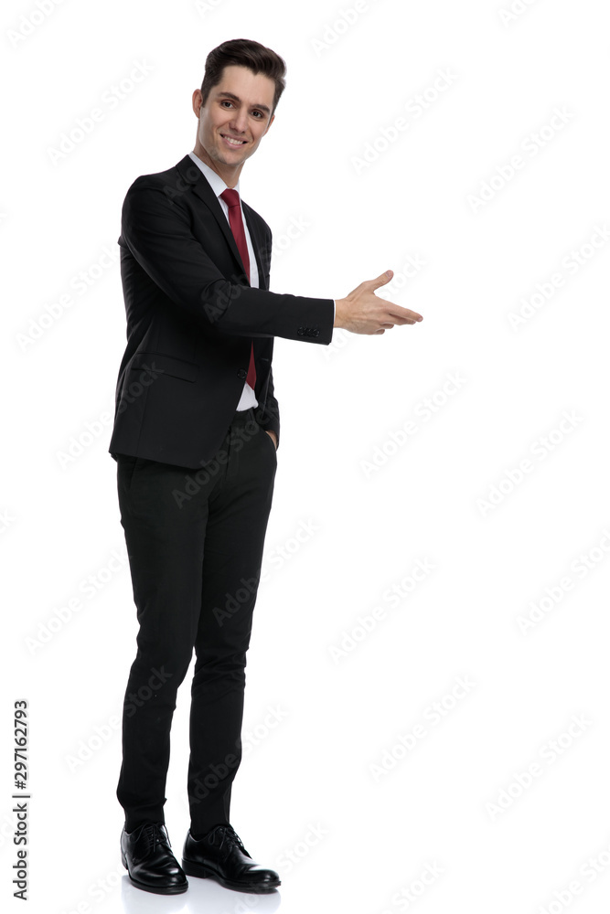 Positive young businessman presenting and smiling Positive young businessman presenting and smiling