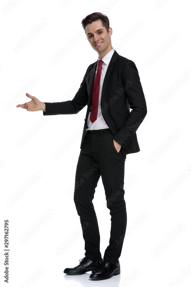 Positive young businessman presenting and standing Positive young businessman presenting and standing