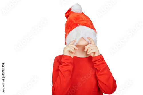 Portrait of teen boy in Santa hat  pulled a hat on his face  isolated on white background. Christmas boy dressed in santa claus hat and red sweater on a white background.