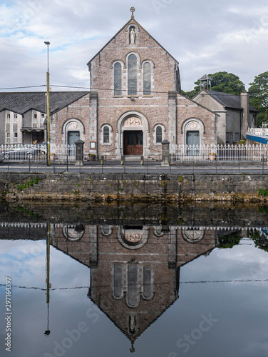 St Mary's Church in Galway city reflected in that calm water of the River Corrib. Taken on an overcast day.
