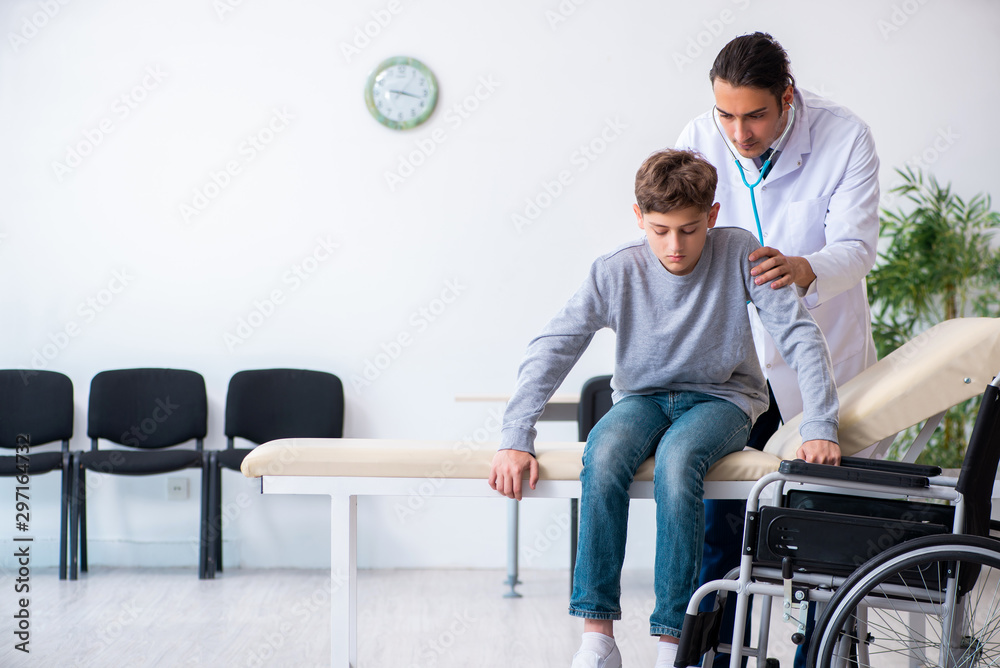 Young male doctor pediatrist and boy in wheel-chair Young male doctor pediatrist and boy in wheel-chair