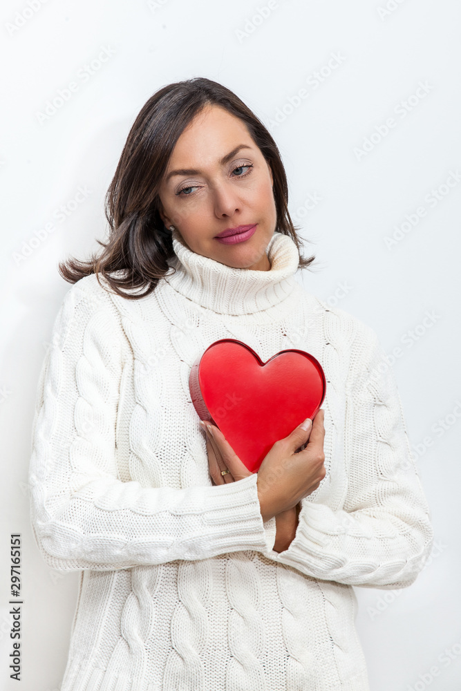 Beautiful sad woman holding a red heart on her hands isolated on white background.. Conceptual for heartbreak, cardiology. Beautiful sad woman holding a red heart on her hands isolated on white background.. Conceptual for heartbreak, cardiology.