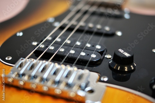 chrome colored bridge and black pickups of an e-guitar closeup