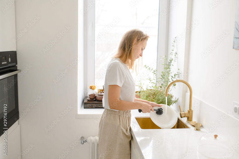 Woman washing dishes in the kitchen. Close up of woman hand. Housewife clean dishes Woman washing dishes in the kitchen. Close up of woman hand. Housewife clean dishes